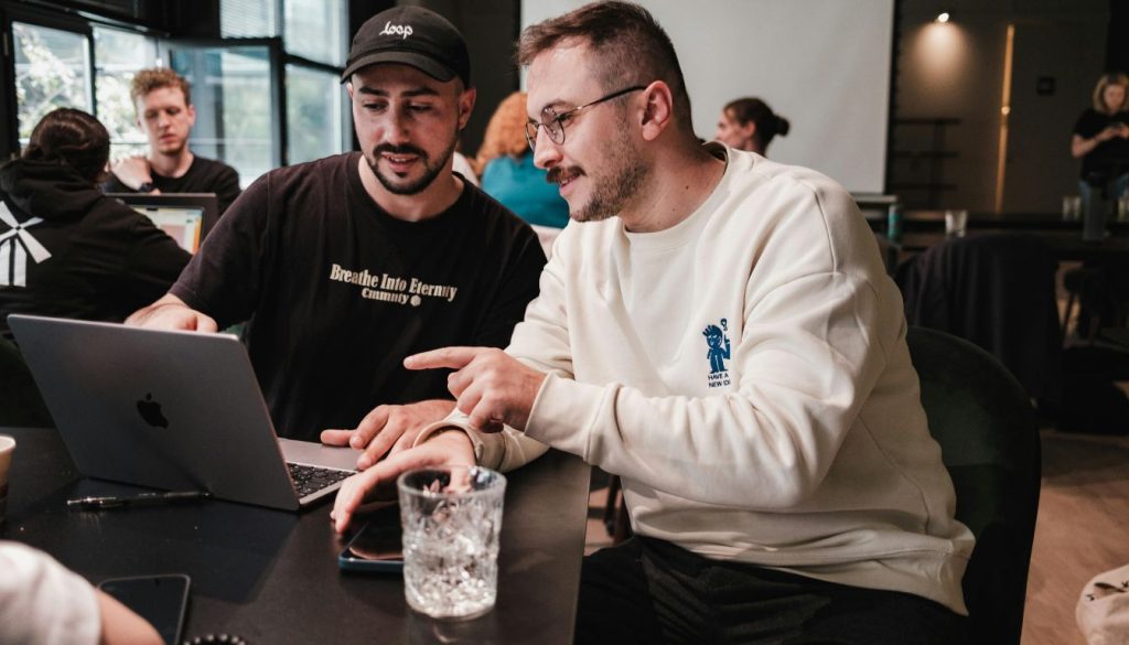 2 hommes sur un ordinateur dans un café